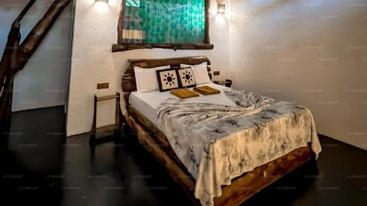 Bedroom with wooden bed and decorative pillows in a room with a green wall.