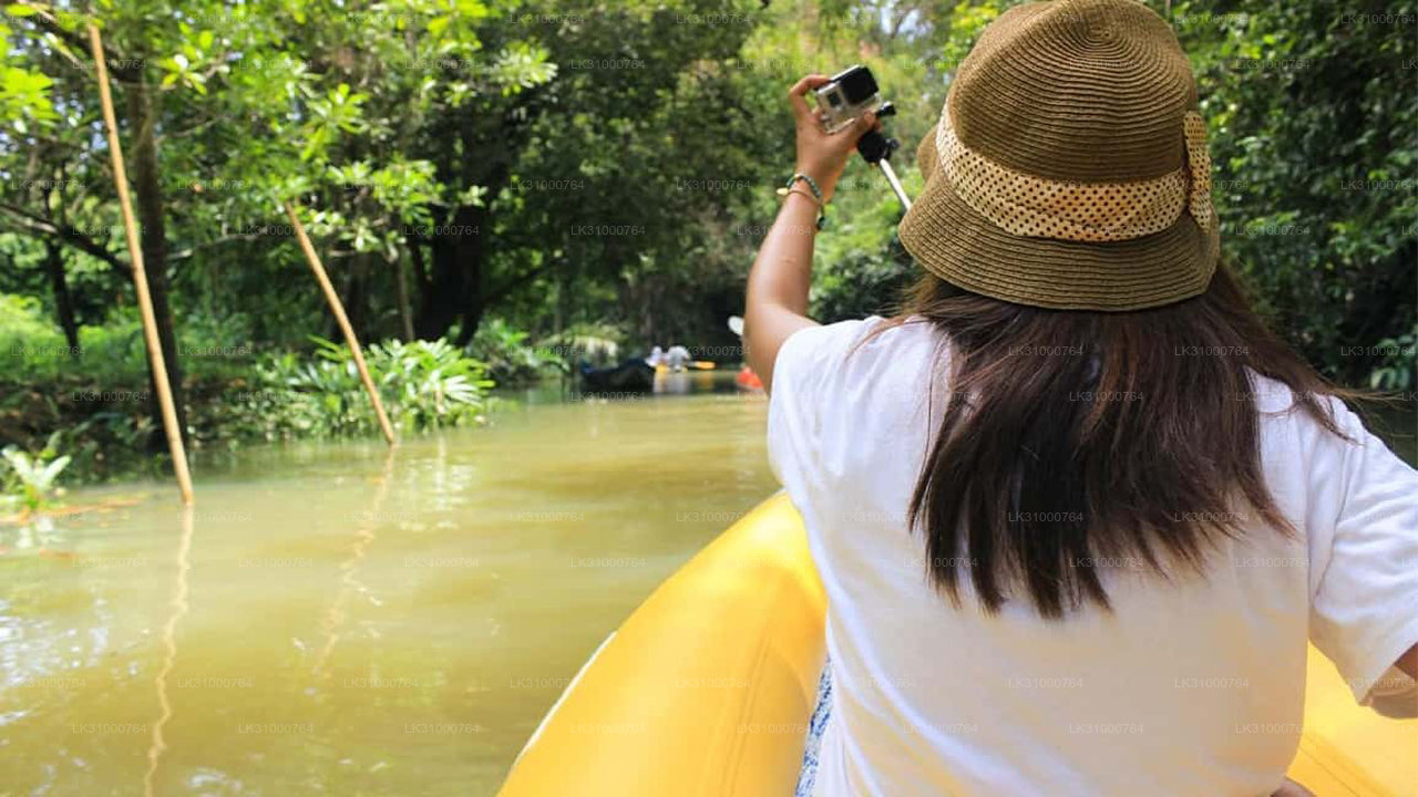 Person in a yellow kayak taking a photo with a smartphone in a lush green setting