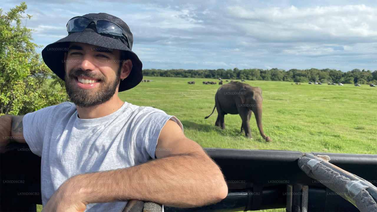 Man in a safari hat with an elephant in the background