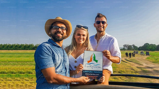 Three people holding a sign with a logo and text in an open field.